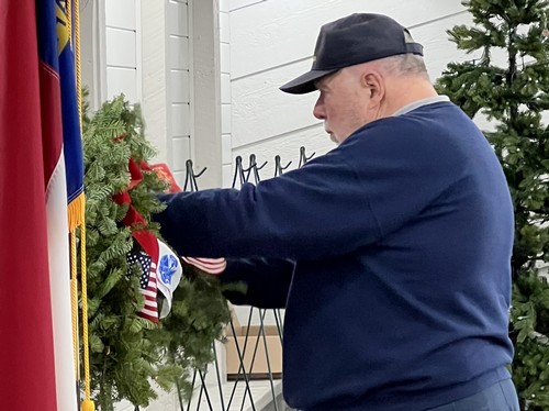 Commander Ed McCloskey places the Marine wreath.